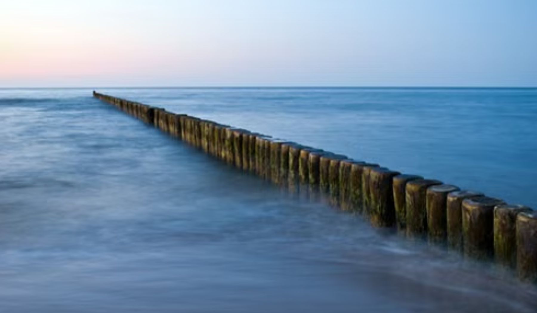 Buhnen im Meer in der Dämmerung — die SoulMe Akademie für Spirituelle Intelligenz